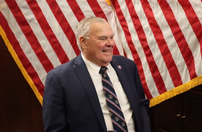 Rep. Baird smiling in front of American flag